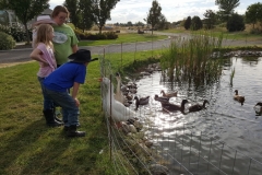 Student with visitors enjoying the pond